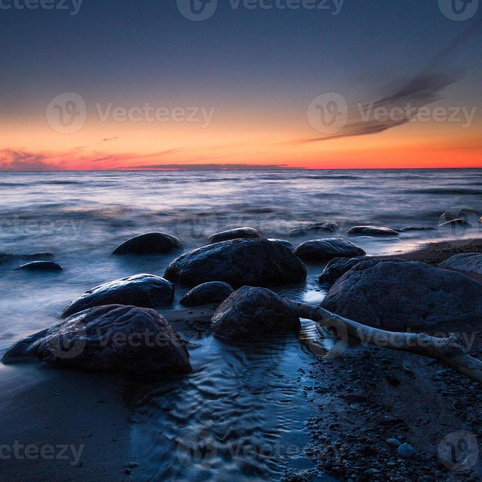 pietre su il costa di il baltico mare a tramonto foto