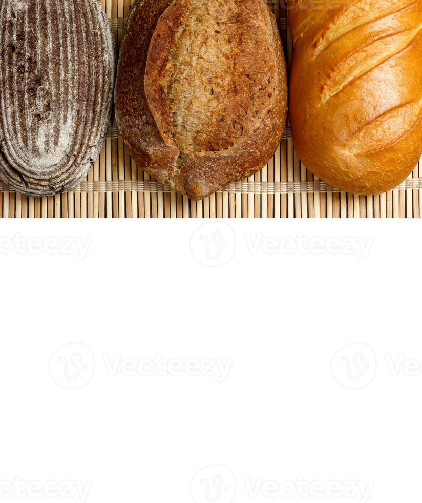 diverso fresco pane su di legno tavola, isolato su bianca sfondo foto