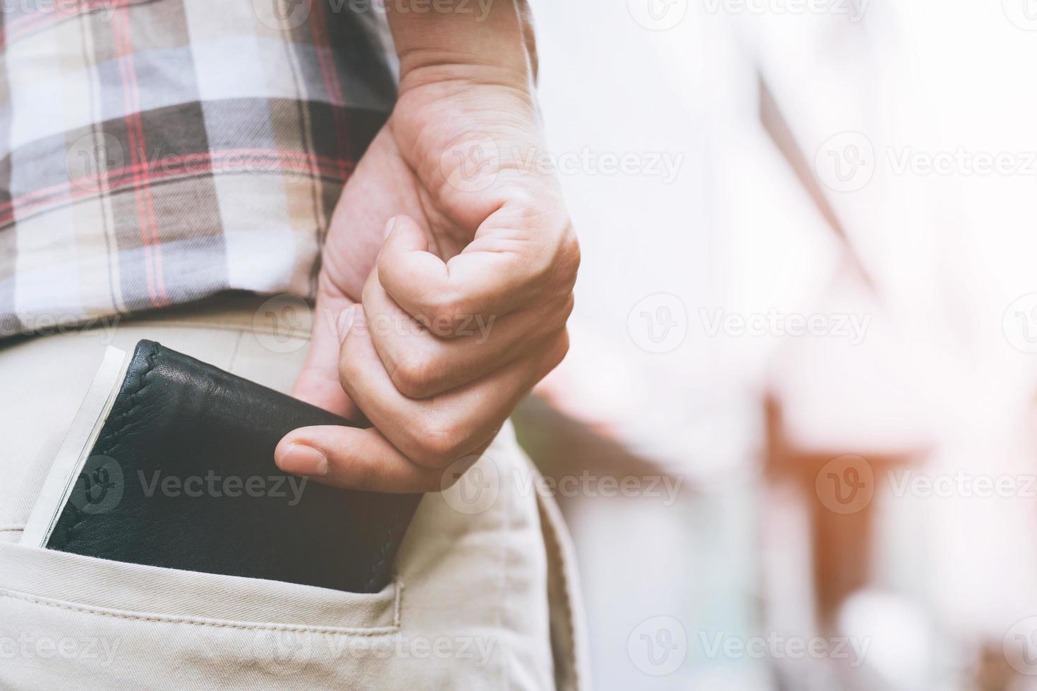 uomo d'affari fiducioso che posa al sicuro tenendo il portafoglio nella tasca posteriore dei pantaloni della tasca posteriore. soldi di risparmio. foto