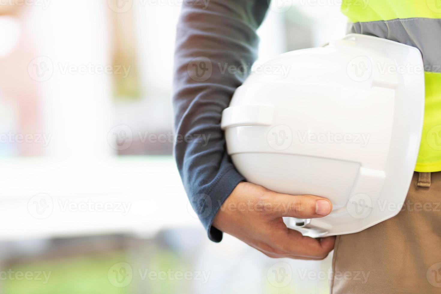 costruzione lavoratore Tenere sicurezza giallo casco e bianca casco con indossare riflessivo capi di abbigliamento per il sicurezza di il opera operazione. all'aperto di costruzione. foto