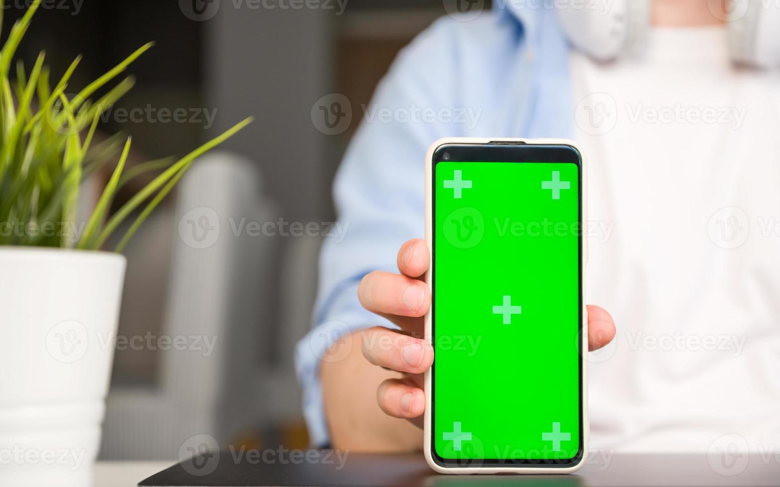 modello Immagine di un' uomo Tenere e mostrandosmartphone con verde croma schermo foto