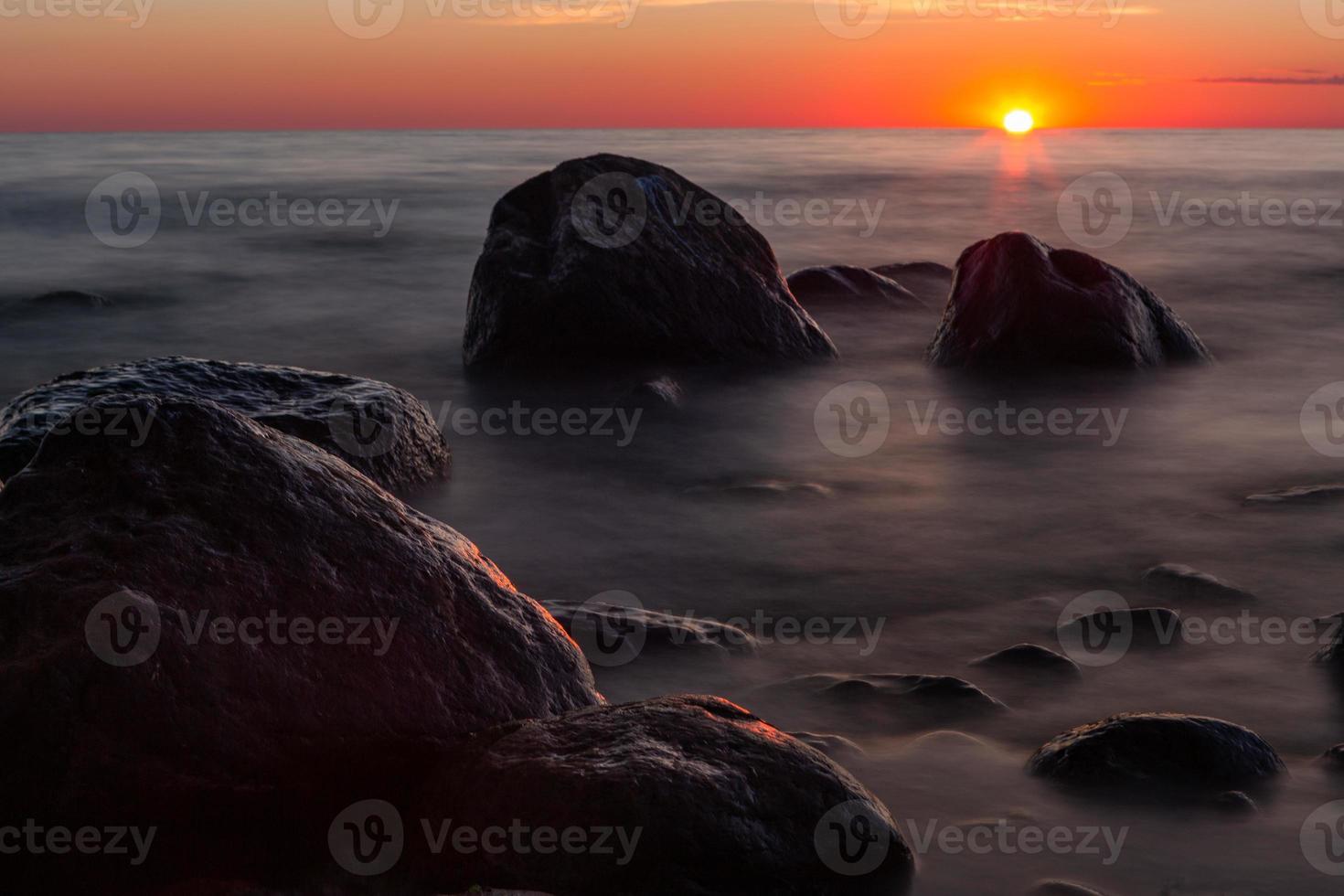 pietre su il costa di il baltico mare a tramonto foto