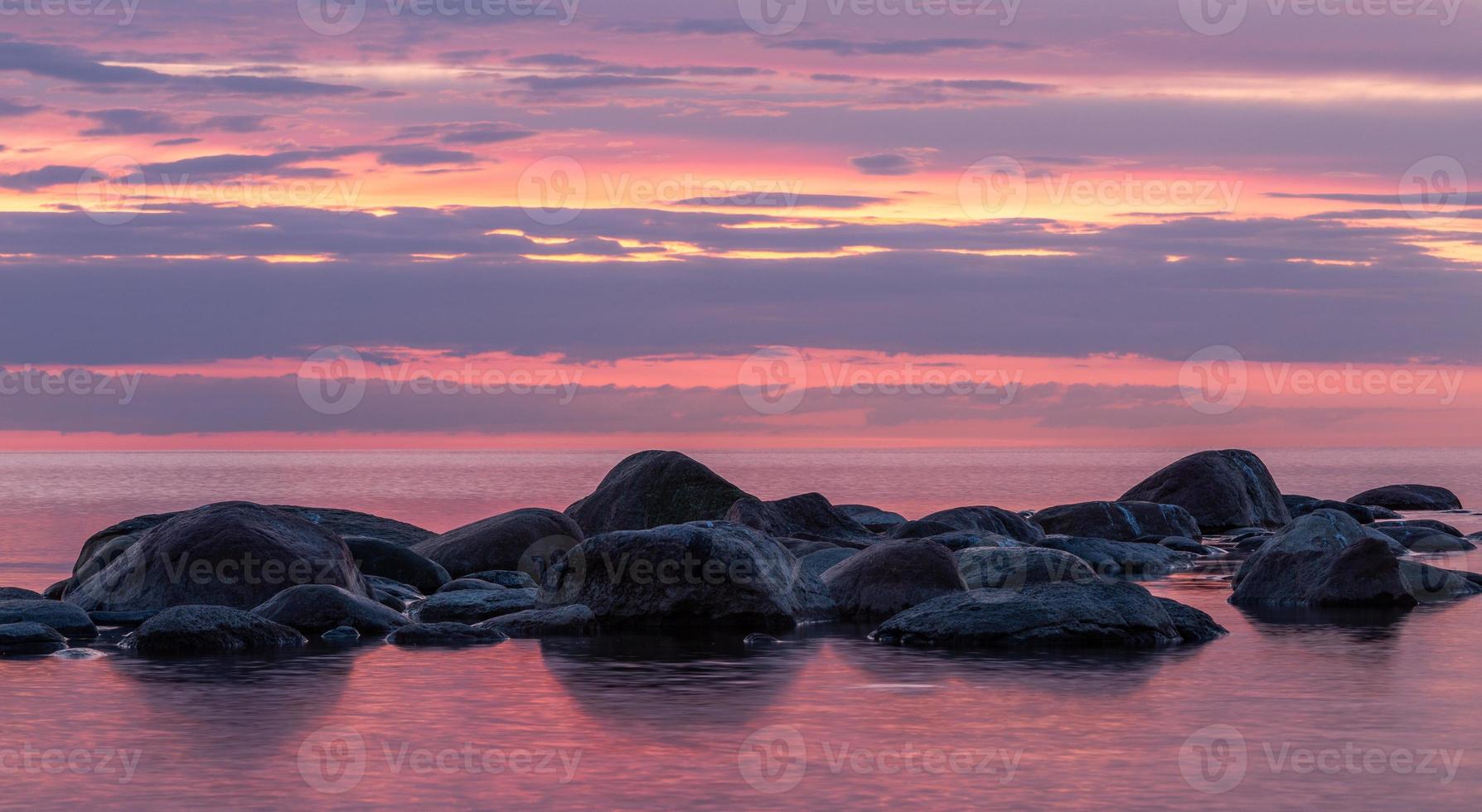 pietre su il costa di il baltico mare a tramonto foto