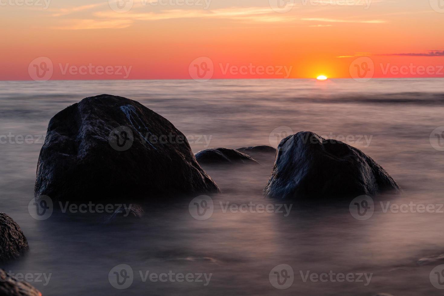 pietre su il costa di il baltico mare a tramonto foto