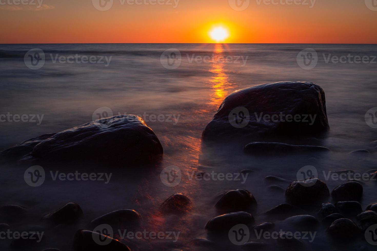 pietre su il costa di il baltico mare a tramonto foto