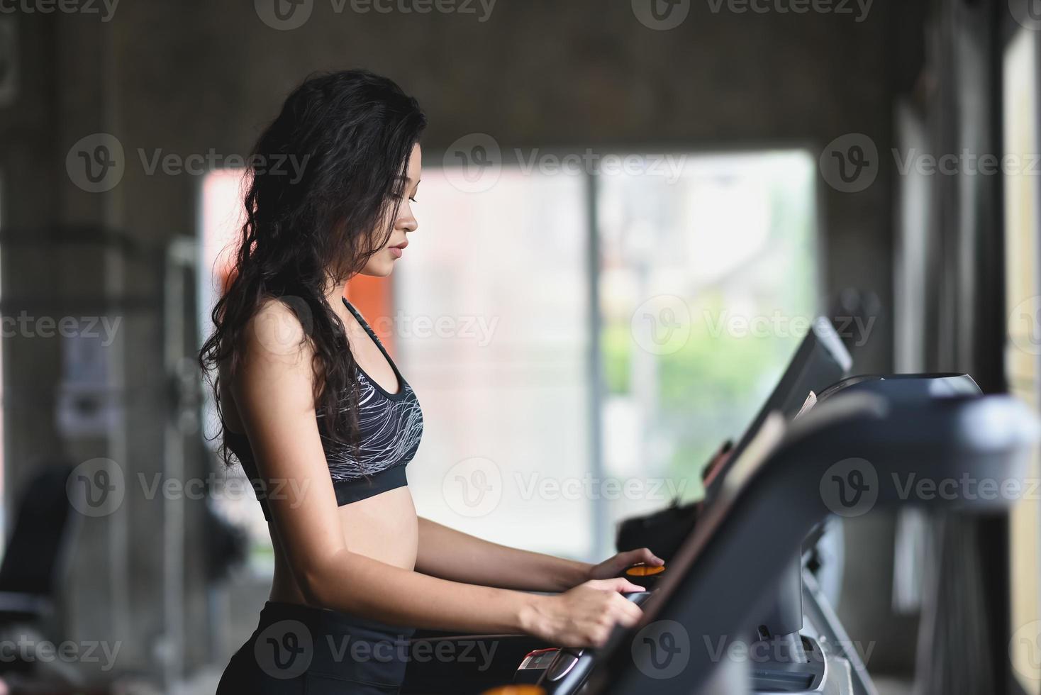 asiatico sport donna in esecuzione su routine nel fitness club. cardio allenamento. salutare stile di vita, donna formazione nel palestra. sport in esecuzione concetto foto