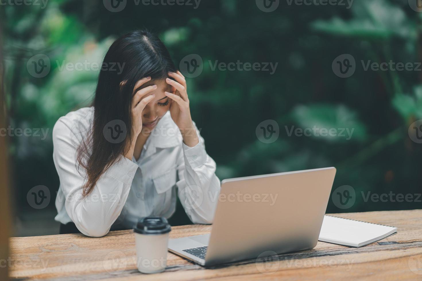 asiatico libero professionista donna mano al di sopra di testa avendo stressante depressione triste tempo mentre Lavorando su il computer portatile a casa. depressione donna triste serio Lavorando a partire dal casa. Lavorando a dovunque concetto. foto