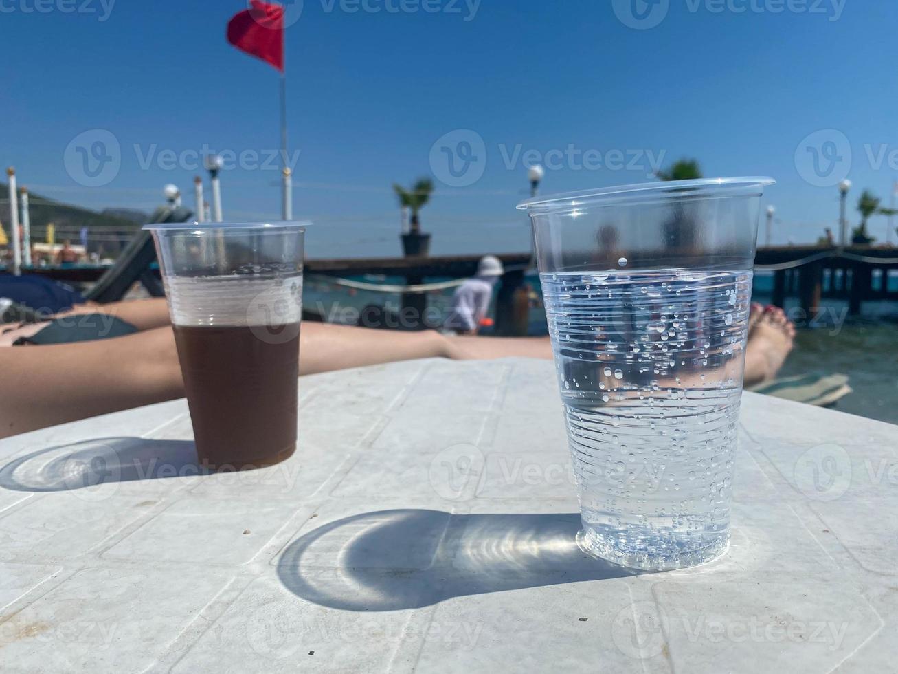 un' freddo bevanda nel un' bicchiere su il spiaggia foto