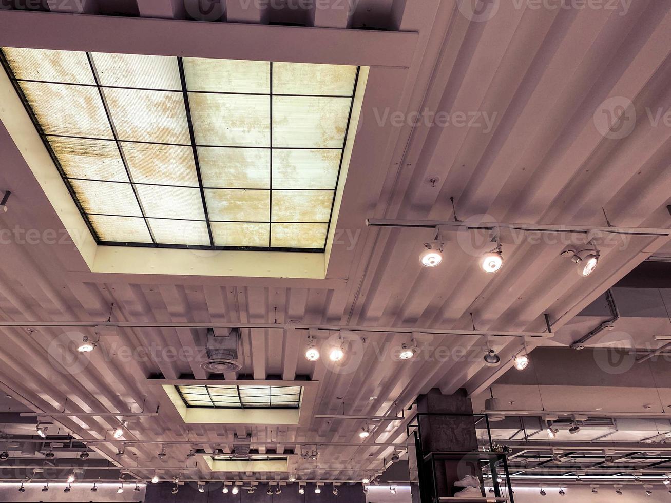 soffitto nel un' nuovo costruzione. metallo foglio su il tetto, nero leggero bulbi allegato per il soffitto. leggero fonti su un' bastone. soffitta stile appartamento foto