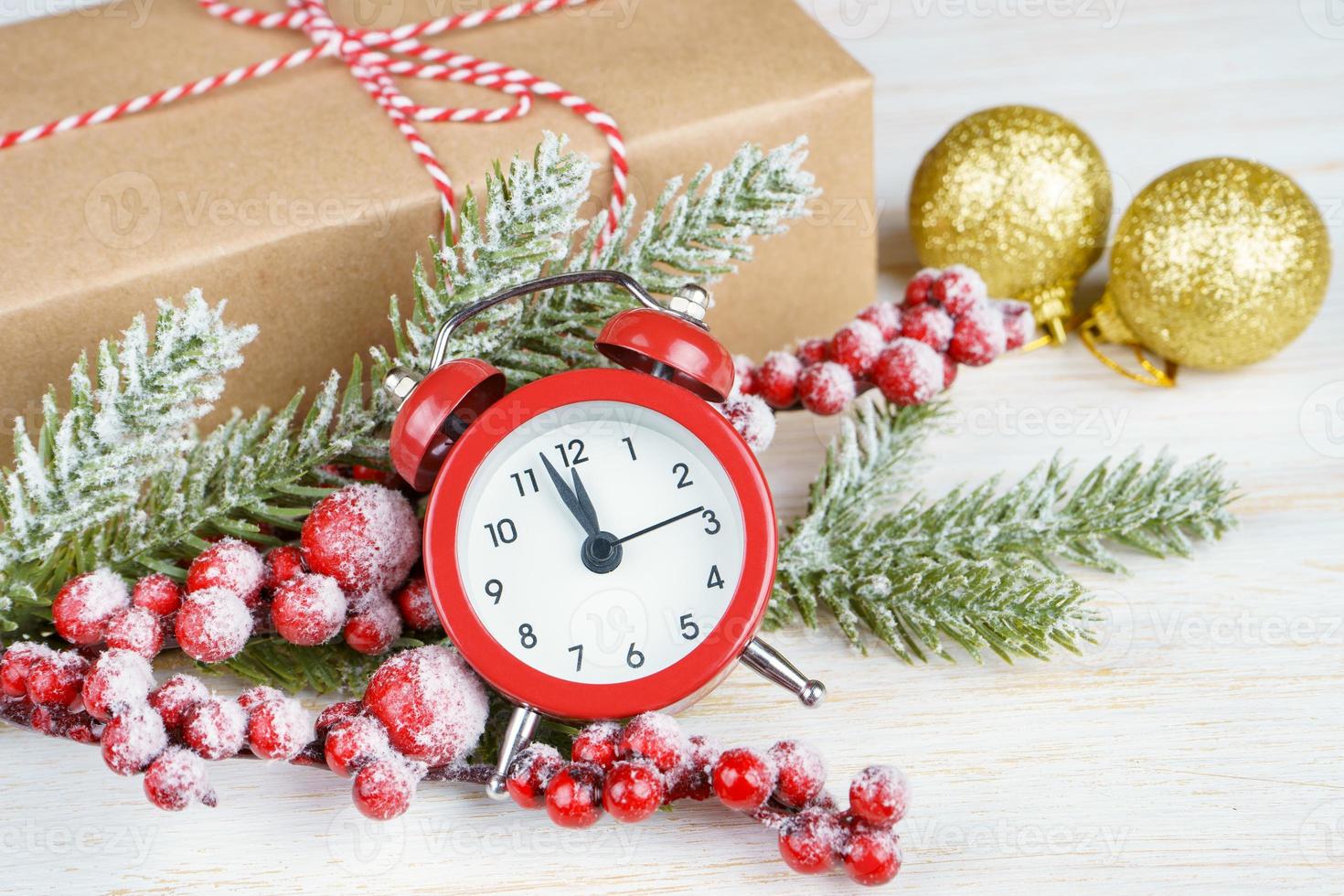 Natale neve abete albero, allarme orologio e regalo scatola su bianca di legno sfondo. foto