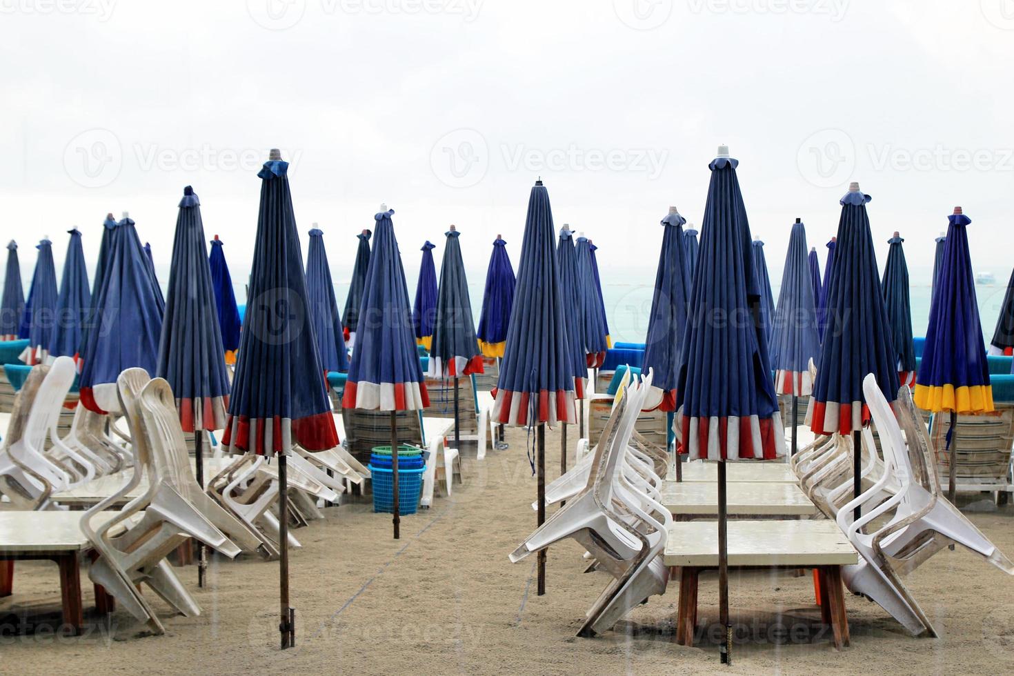 il vuoto spiaggia con un' lotto di lettini e ombrelli nel un' piovoso tempo atmosferico. pattaya, Tailandia. foto