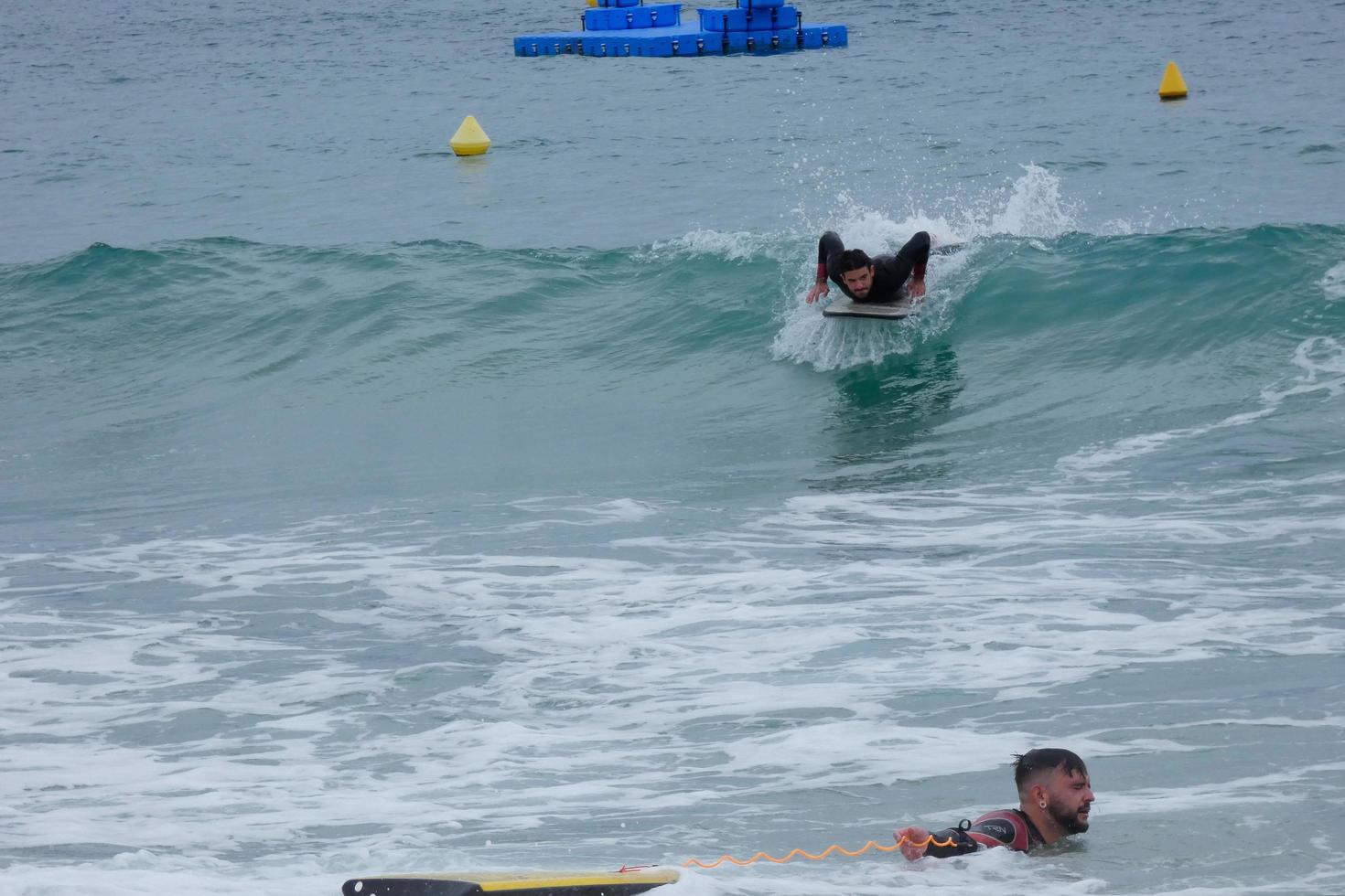 surfers equitazione onde nel un' sballottato dalla tempesta mare foto