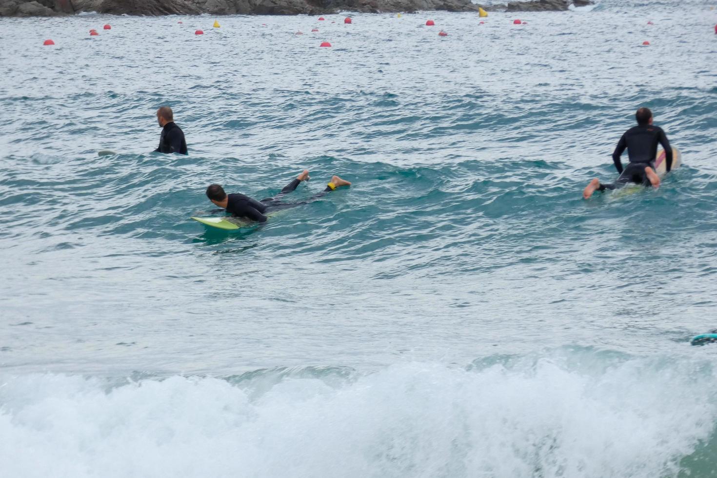 surfers equitazione onde nel un' sballottato dalla tempesta mare foto