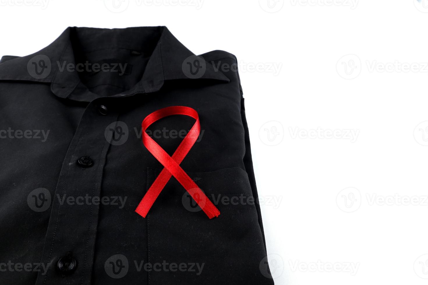rosso nastro su un' nero camicia su un' bianca sfondo. moderno trattamento e assistenza sanitaria. AIDS consapevolezza concetto. foto