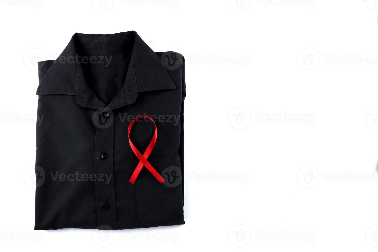 rosso nastro su un' nero camicia su un' bianca sfondo. moderno trattamento e assistenza sanitaria. AIDS consapevolezza concetto. foto