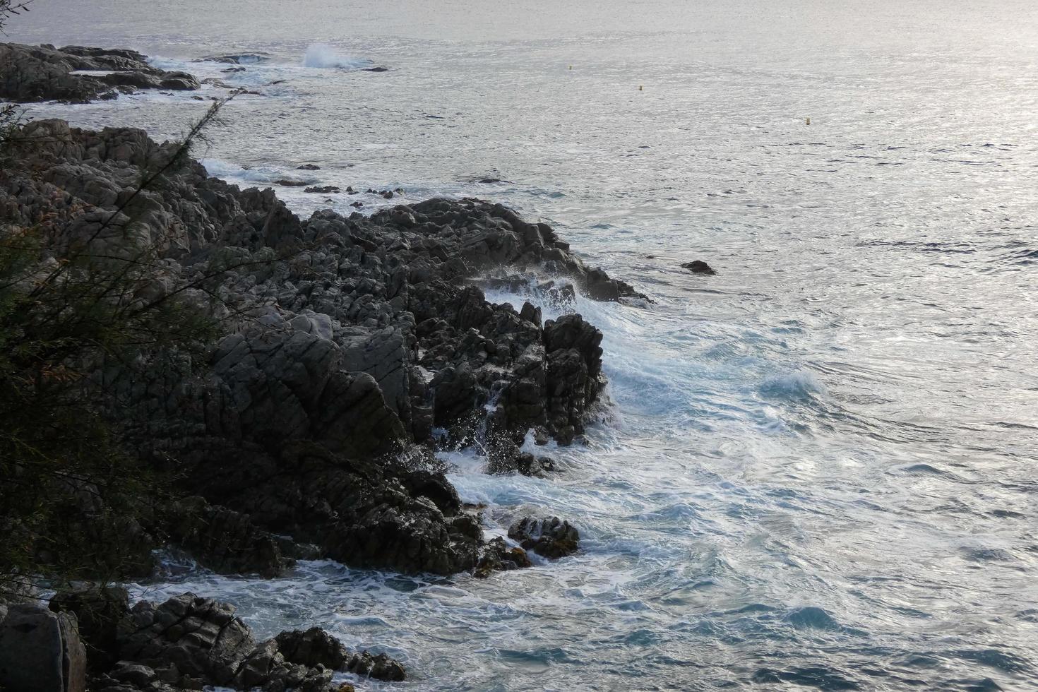 mare raggiungendo il rocce la creazione di spruzzi di schiuma foto