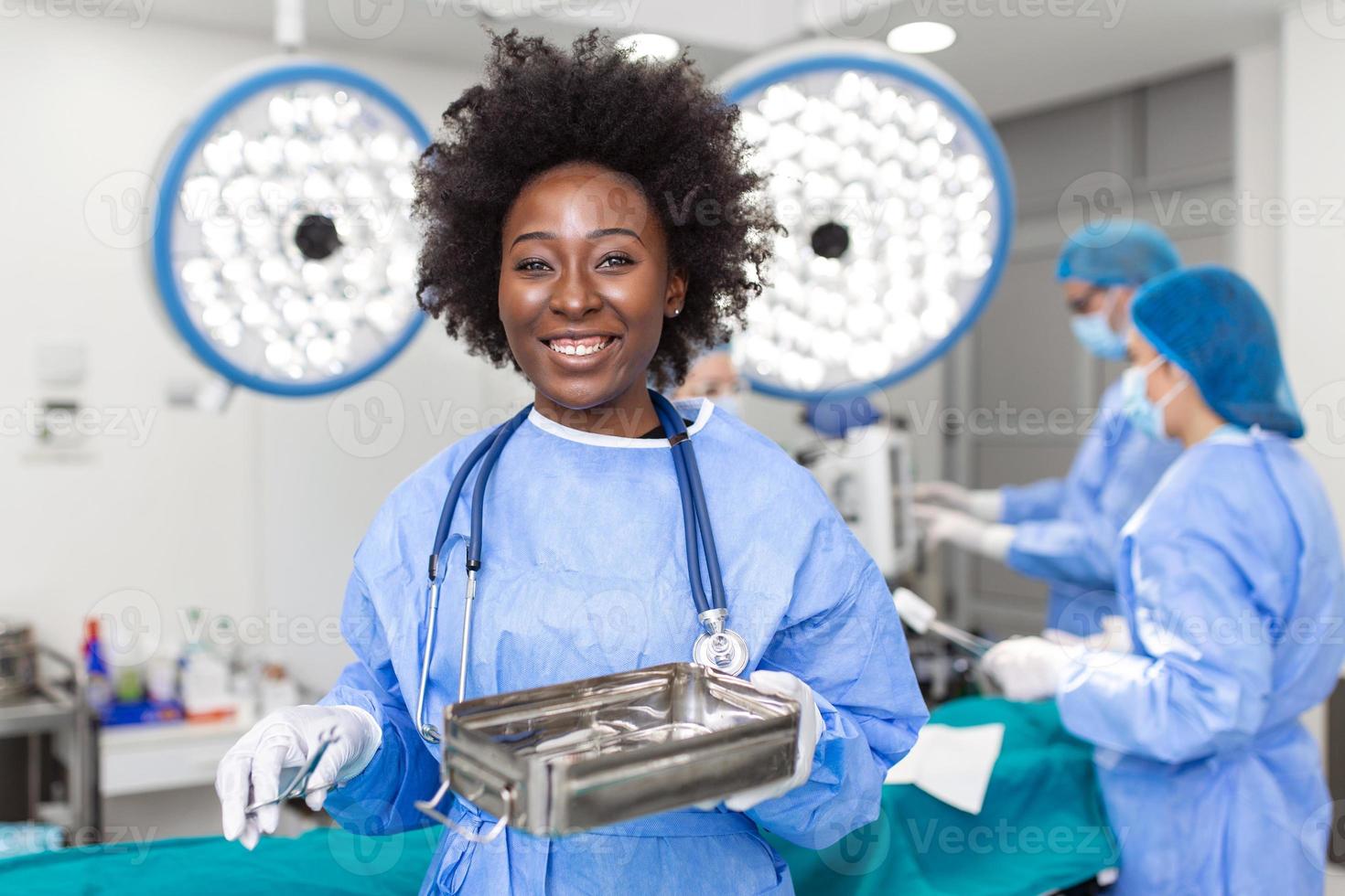 ritratto di africano americano donna chirurgo in piedi nel operativo camera, pronto per opera su un' paziente. femmina medico lavoratore nel chirurgico uniforme nel operazione Teatro. foto