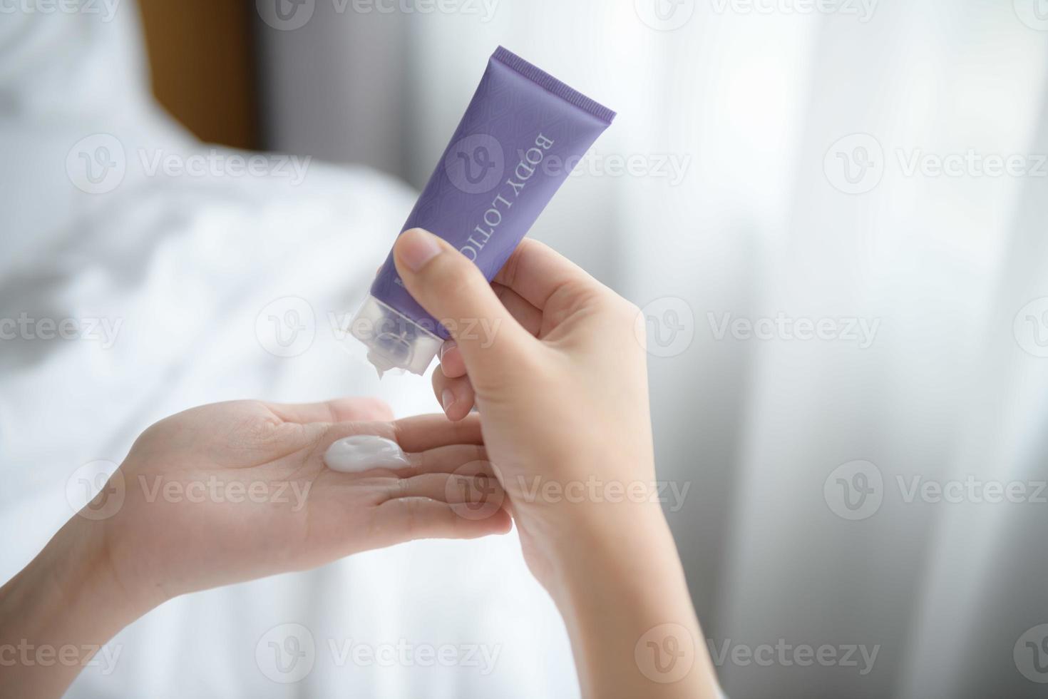 vicino su di donne l'applicazione corpo lozione crema su mano. foto