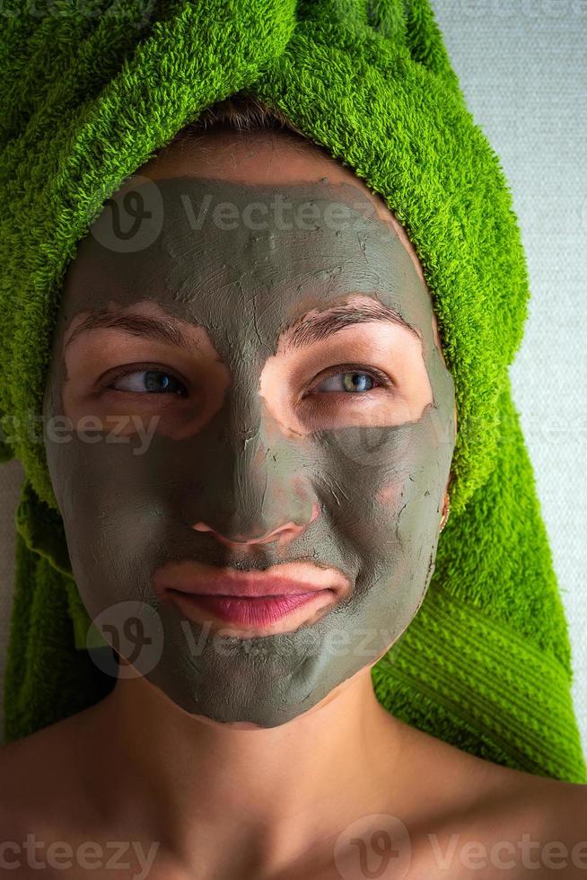 giovane donna con argilla maschera su sua viso contro leggero sfondo, spazio per testo. foto