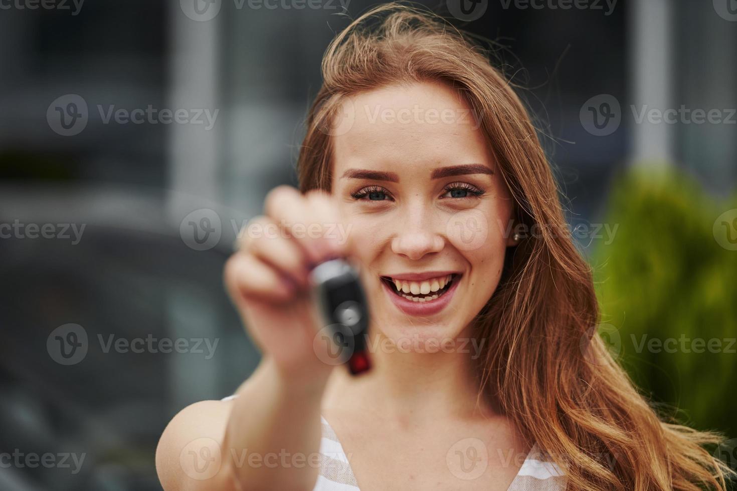 ritratto di allegro bionda con chiavi di sua marca nuovo auto foto