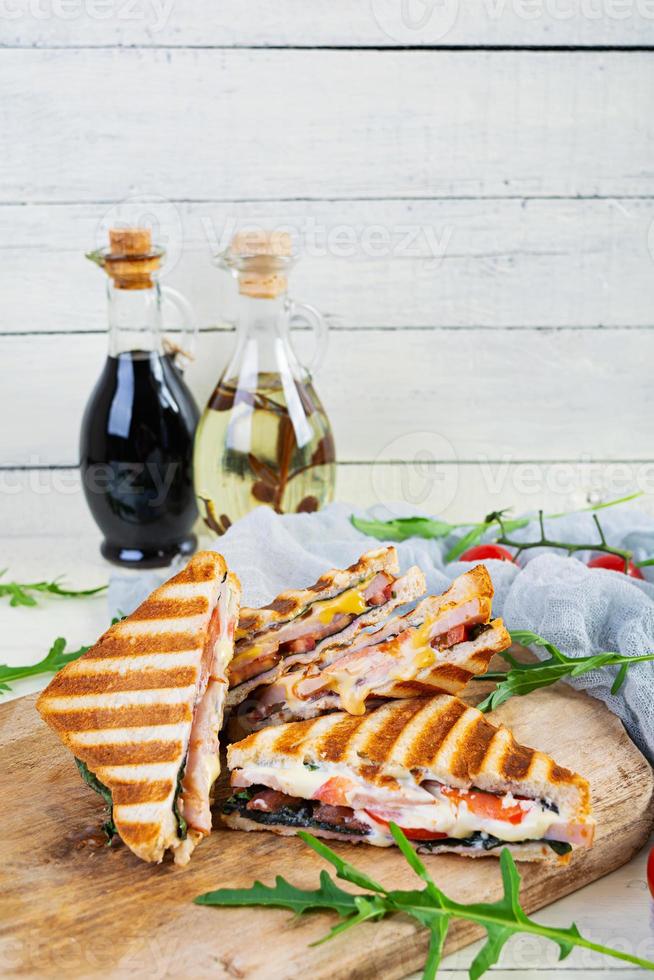 Sandwich con prosciutto, formaggio, mostarda foglie, pomodori e cipolla. gustoso grigliato panini foto