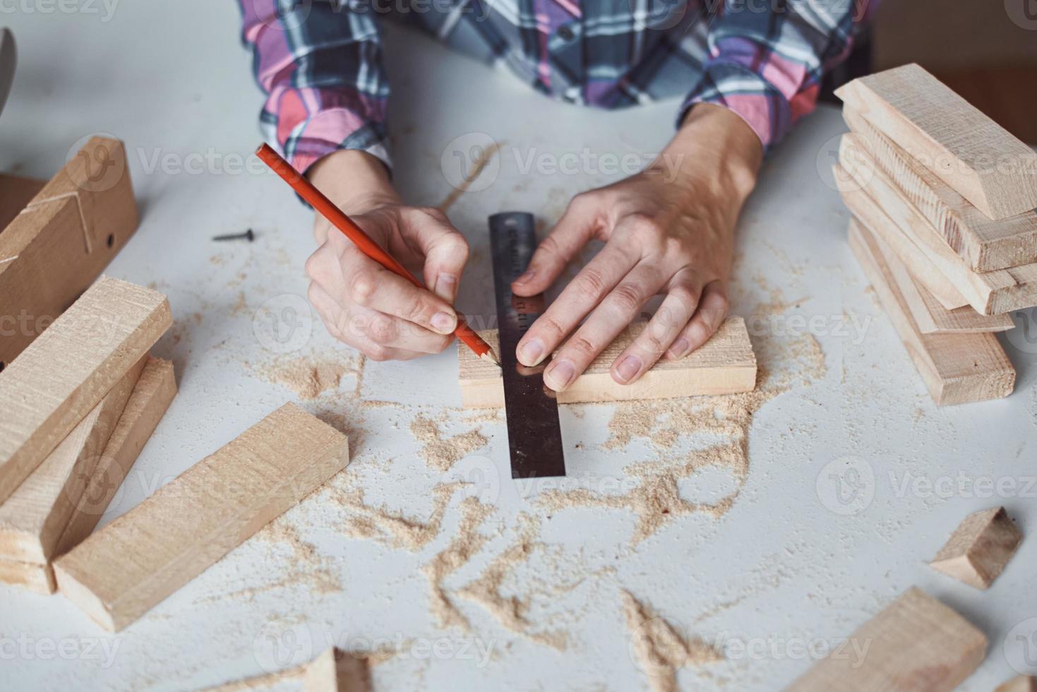 falegname mani assunzione misurazione con un' matita di di legno tavola. foto