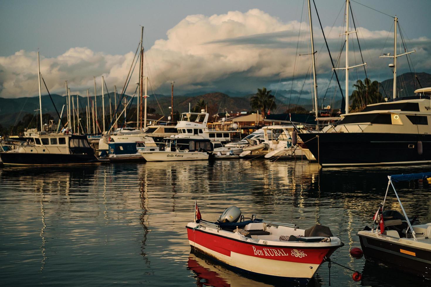 fethiye, tacchino - novembre 24, 2022. inverno tramonto nel fethiye baia, selettivo messa a fuoco su il rosso barca. retrò stile, telaio con film grano e rumore foto