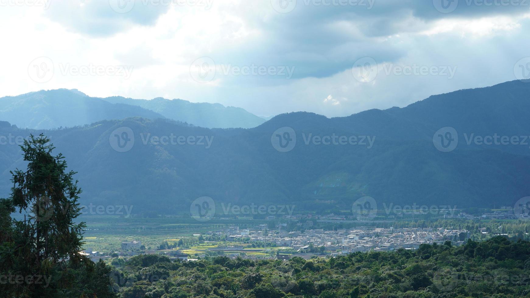 il raccolta giallo riso campo Visualizza collocato nel il valle tra il montagne con il nuvoloso cielo come sfondo foto