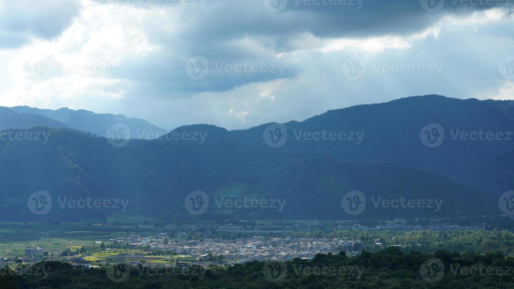 il raccolta giallo riso campo Visualizza collocato nel il valle tra il montagne con il nuvoloso cielo come sfondo foto