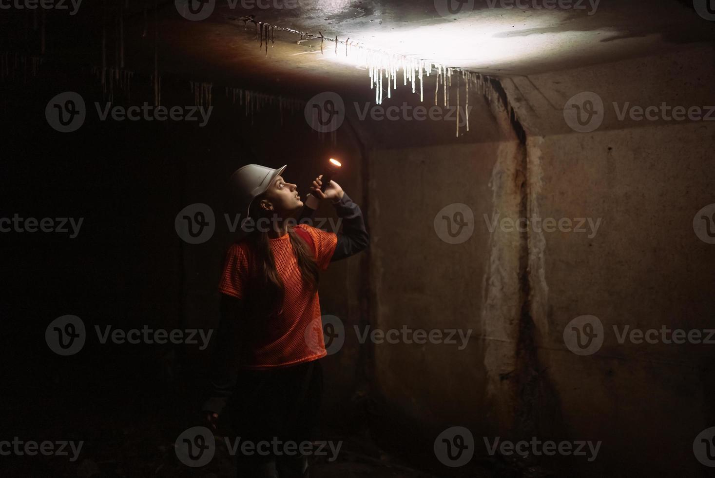 femmina scavatrice con torcia elettrica esplora il tunnel foto