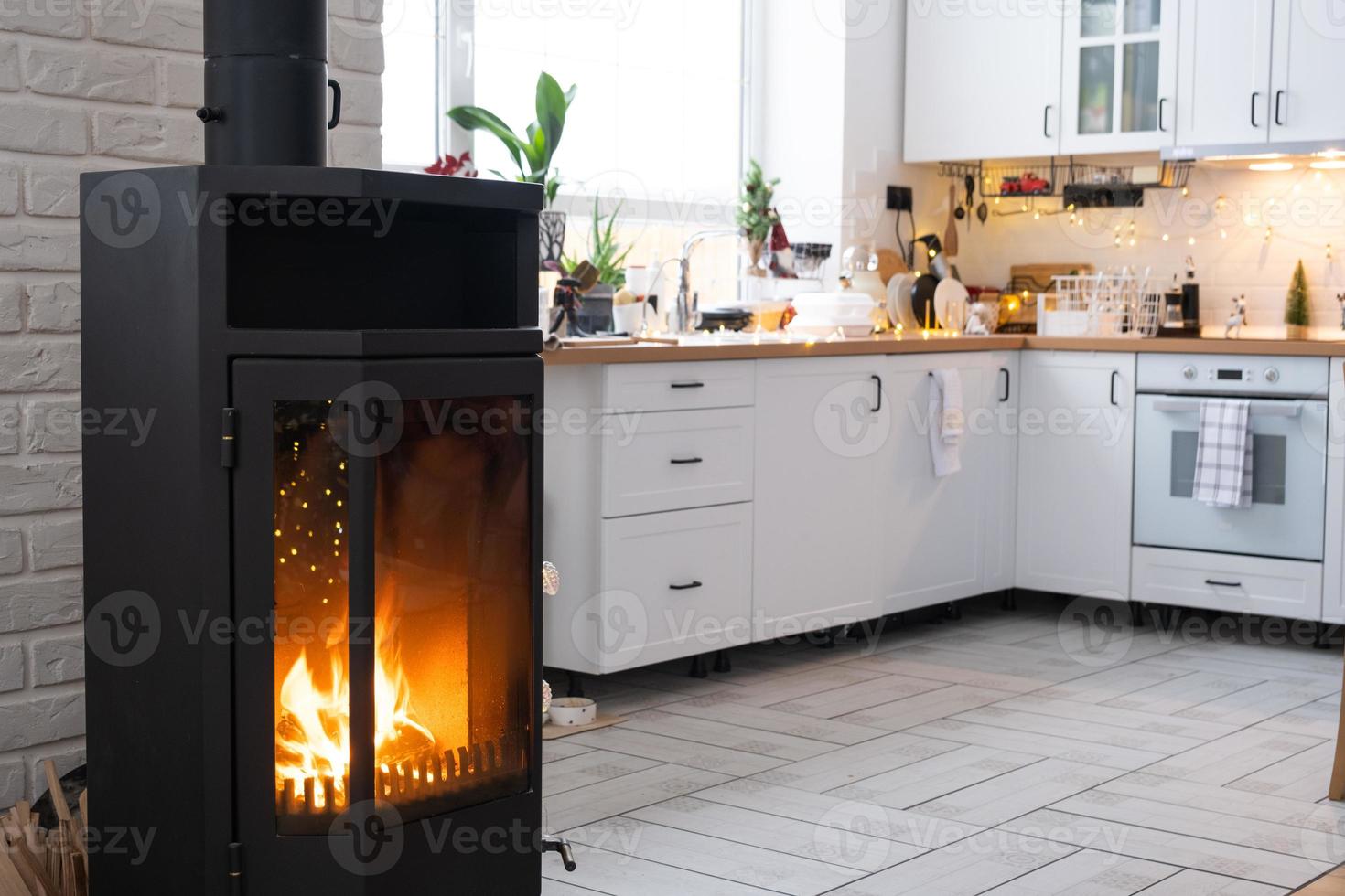 festivo interno di Casa è decorato per Natale e nuovo anno nel soffitta stile con nero fornello, il camino, Natale albero. caldo studio camera con bianca cucina, ardente Di legno, accogliente e riscaldamento di casa foto