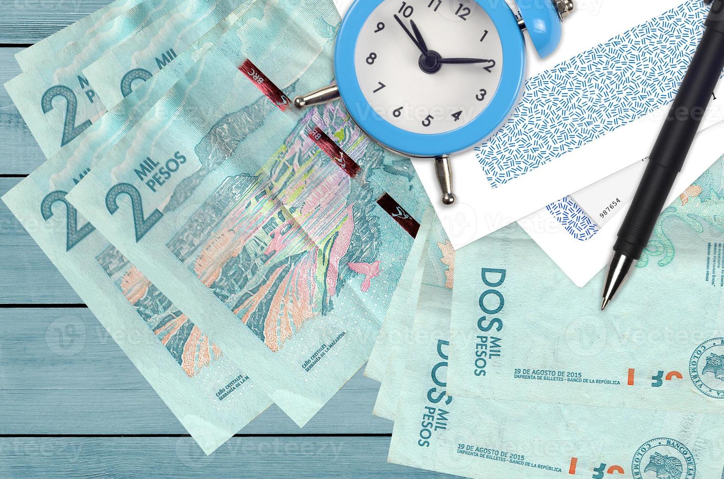 2 colombiano pesos fatture e allarme orologio con penna e buste. imposta stagione concetto, pagamento Scadenza per credito o prestito. finanziario operazioni utilizzando postale servizio foto