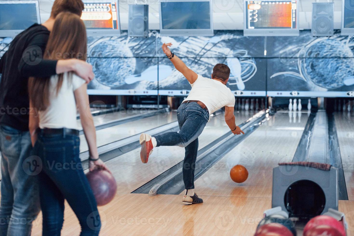 fallo con forza leggera. i giovani amici allegri si divertono al bowling club durante i fine settimana foto