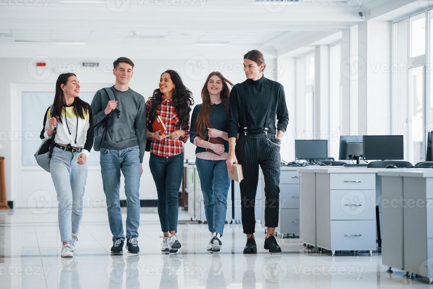 unità delle persone. gruppo di giovani lavoratori che camminano in ufficio durante la pausa foto