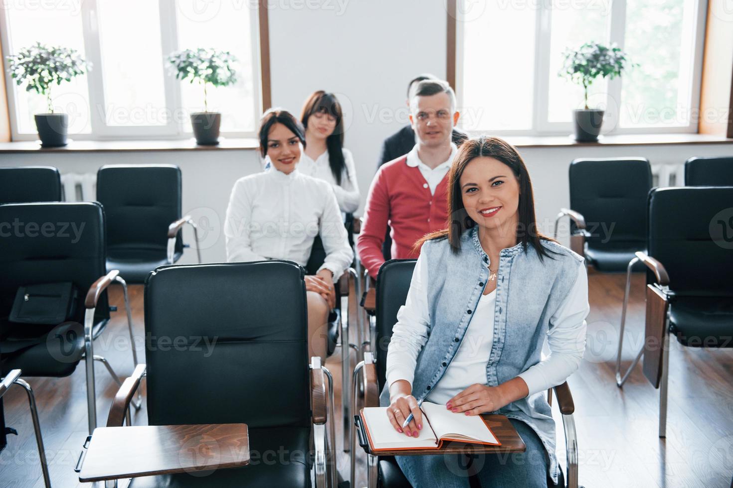 guardando la telecamera. gruppo di persone alla conferenza di lavoro nella moderna classe durante il giorno foto