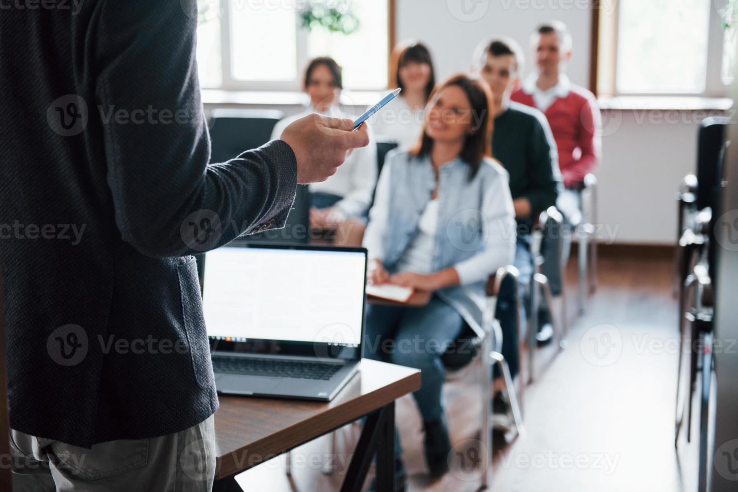 tutti sorridono e ascoltano. gruppo di persone alla conferenza di lavoro nella moderna classe durante il giorno foto