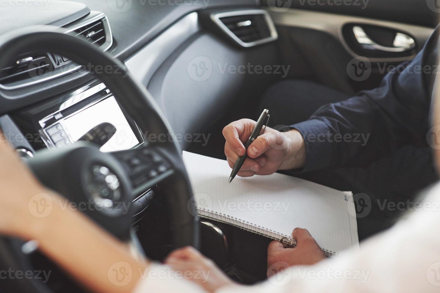 scrittura importante informazione. assistente manager dando consigli e Aiuto per il cliente nel automobile salone foto