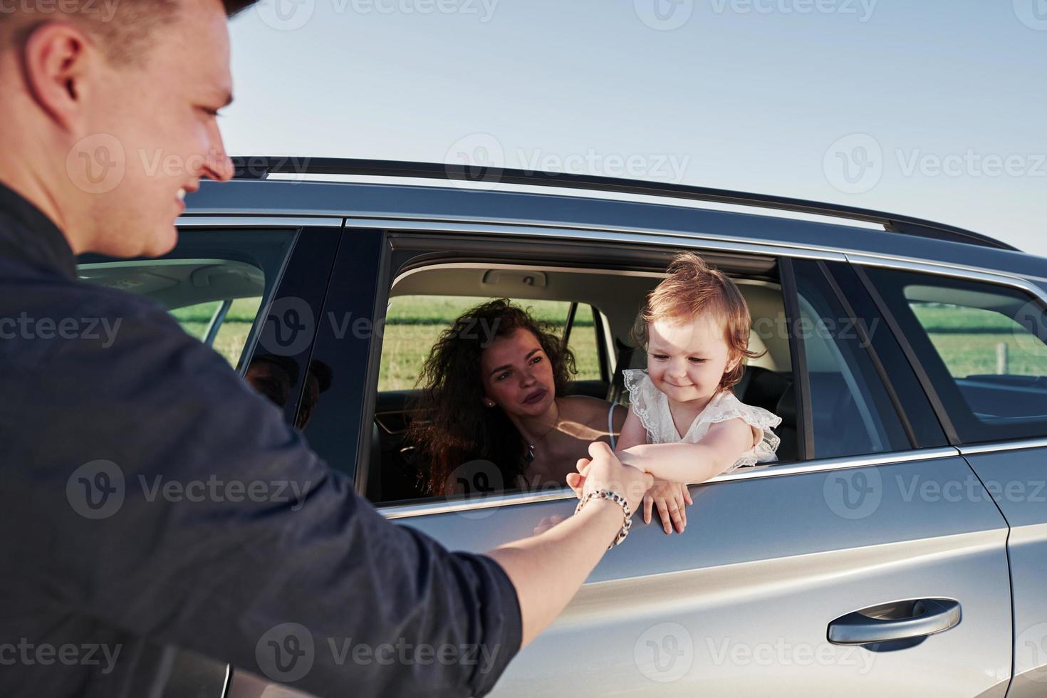 dà mano per scuotere. bellissimo persone è nel il moderno auto a loro fine settimana foto