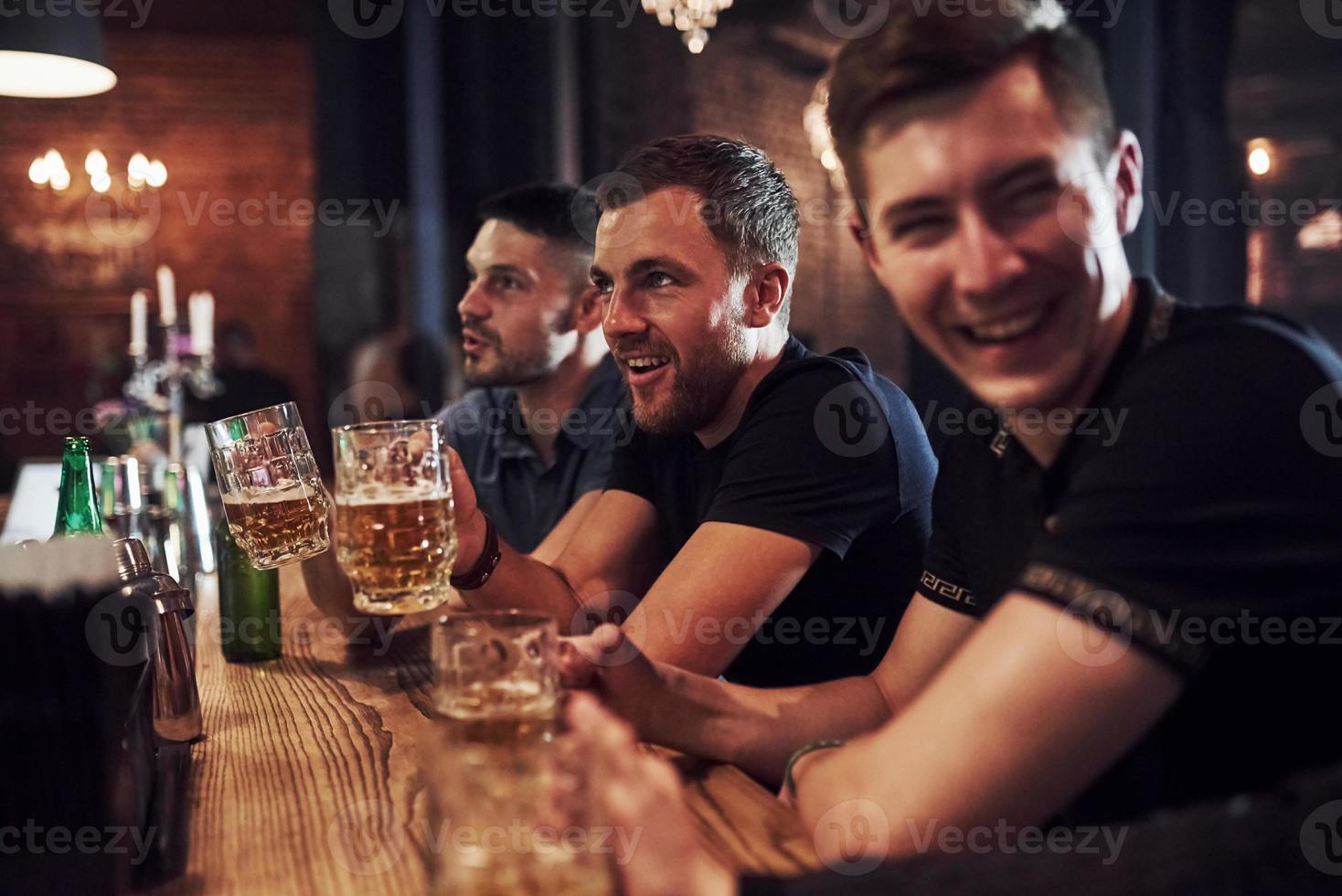 positivo le persone. amici riposo nel il pub con birra nel mani. avendo conversazione foto