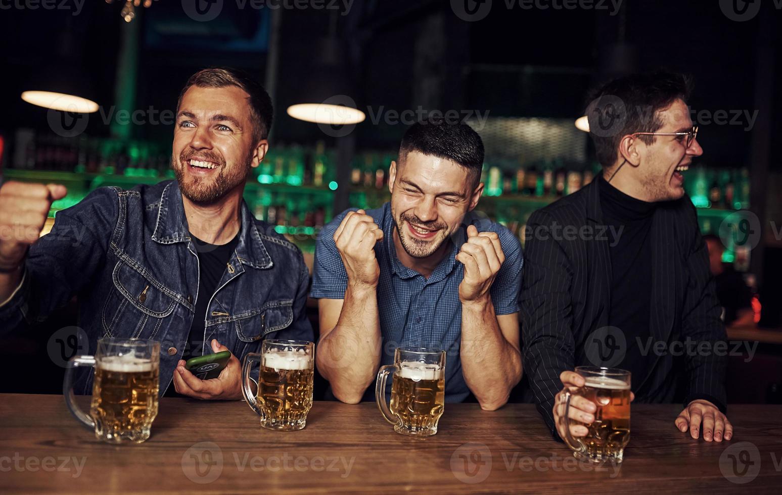 avendo divertimento. amici riposo nel il pub con alcool nel mani foto