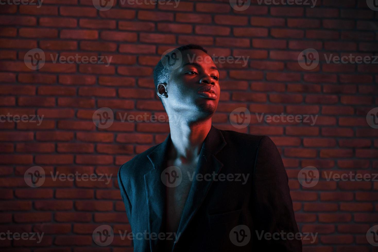 futuristico neon illuminazione. giovane africano americano uomo nel il studio foto