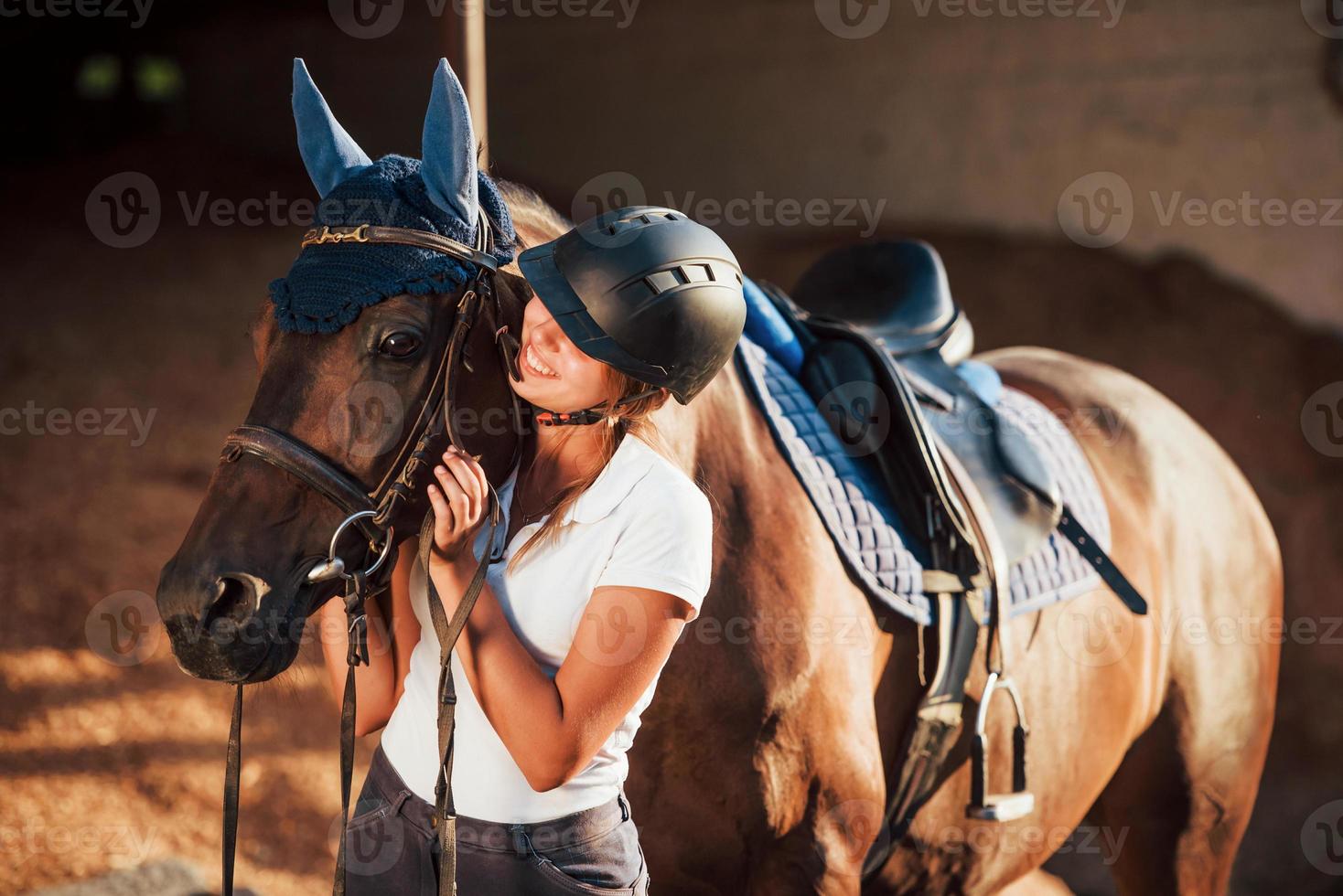 pronto per il giro. amazzone nel uniforme e nero protettivo casco con sua cavallo foto