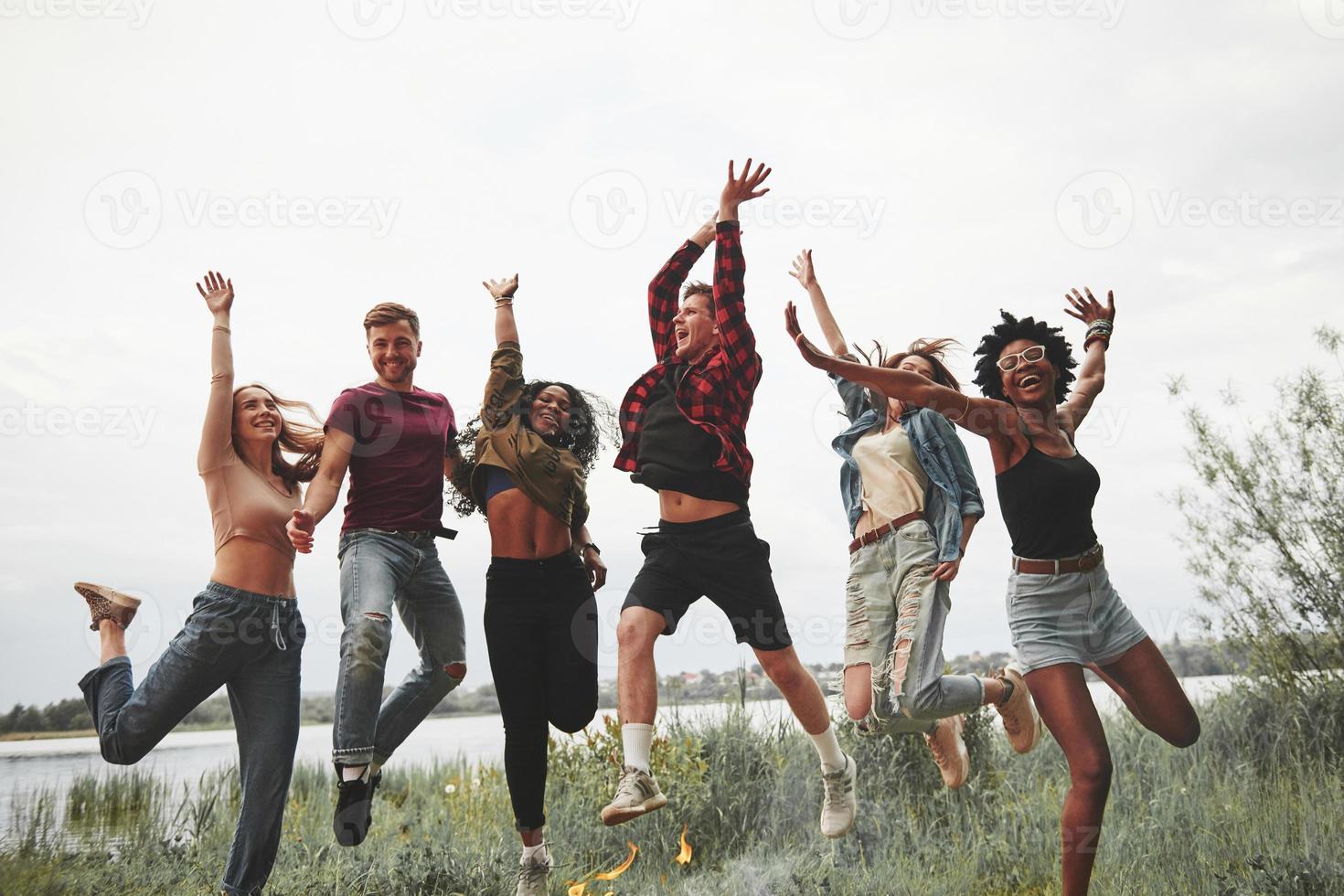 leggero estate Abiti. gruppo di persone avere picnic su il spiaggia. amici avere divertimento a fine settimana tempo foto