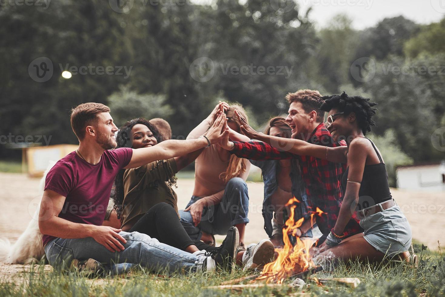 Qui noi incontrare ancora. gruppo di persone avere picnic su il spiaggia. amici avere divertimento a fine settimana tempo foto