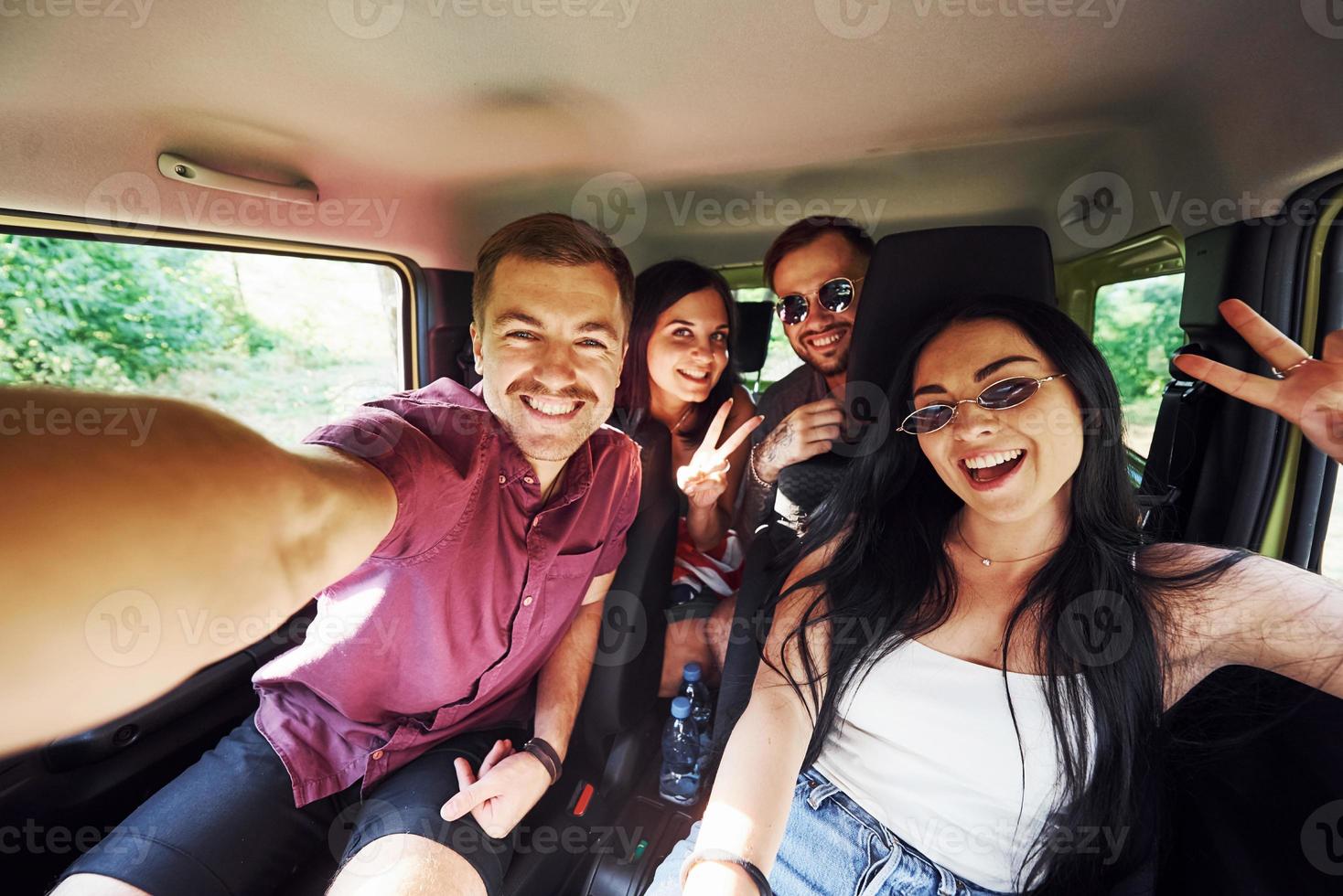 giovane e allegro persone fabbricazione un' autoscatto dentro un' macchina. avendo fine settimana foto