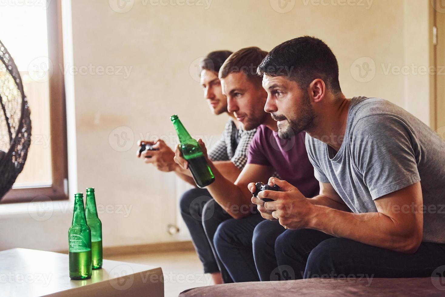 gruppo di amici avere divertimento giocando consolle gioco in casa a vivente camera foto