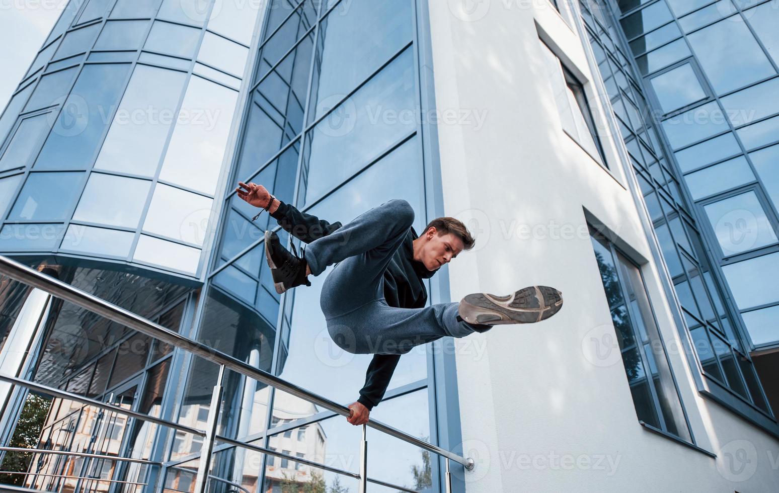 giovane uomo fare parkour nel il città a giorno. concezione di estremo gli sport foto