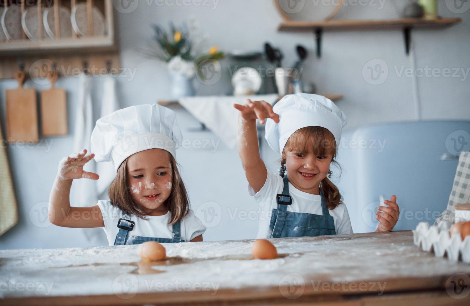 giocando con uova. famiglia bambini nel bianca capocuoco uniforme preparazione cibo su il cucina foto