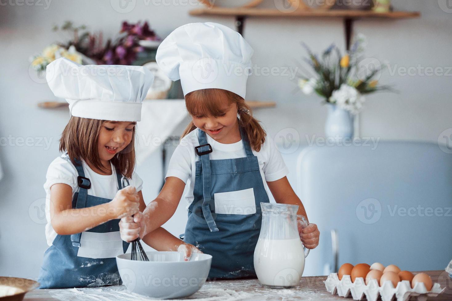 famiglia bambini nel bianca capocuoco uniforme preparazione cibo su il cucina foto