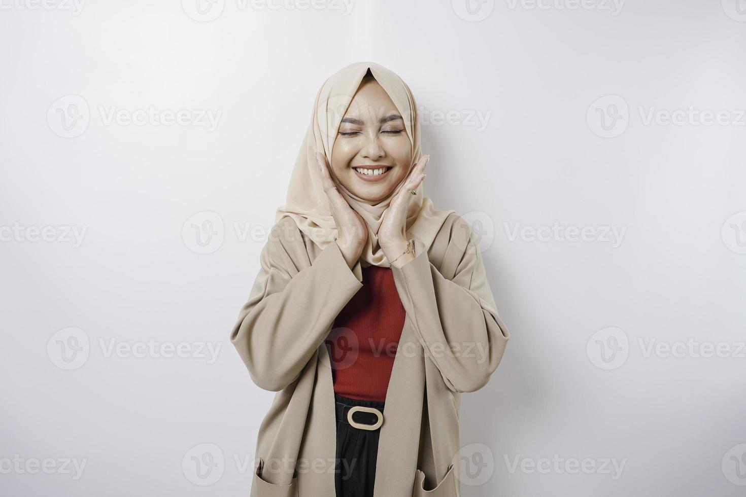 ritratto di un' fiducioso sorridente asiatico musulmano donna in piedi e guardare a il telecamera isolato al di sopra di bianca sfondo foto